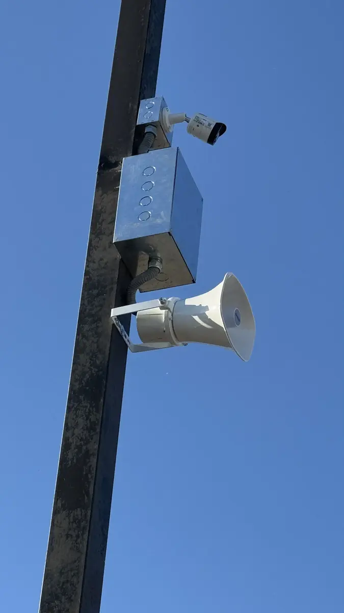 Cámara de seguridad y altavoz de alerta en instalación industrial